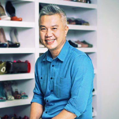 Terance Yow, smiling man in blue shirt against white shelving backdrop
